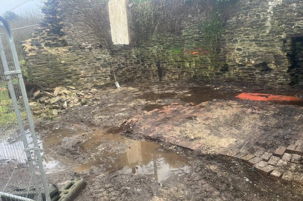 After: site cleared back to the original stone walls, muddy ground ready for next work